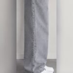 Side view of grey wide leg jeans stacking over white sneakers – Arshmee Fashion