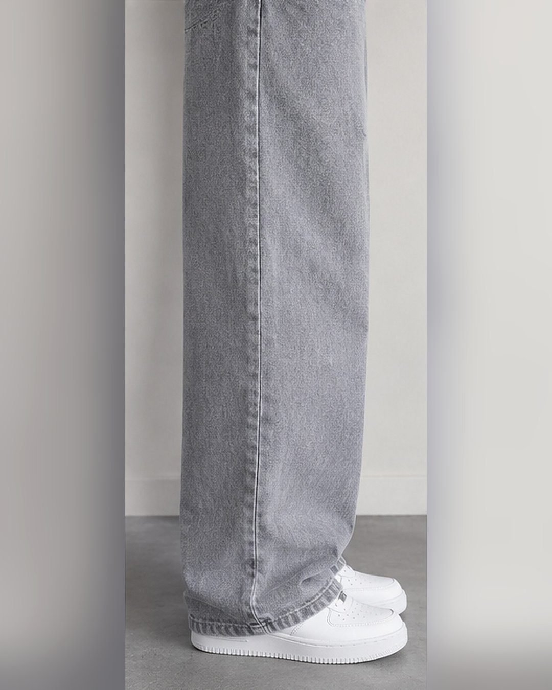 Side view of grey wide leg jeans stacking over white sneakers – Arshmee Fashion